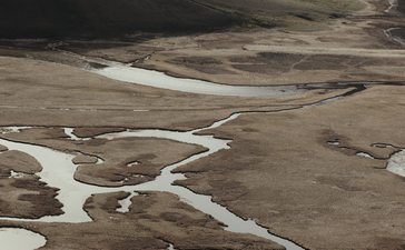 Winding river through arid mountains near Amangani, Wyoming, USA.