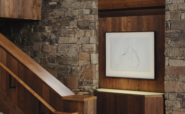 Grand staircase with wooden handrail and stone walls at Amangani, USA.