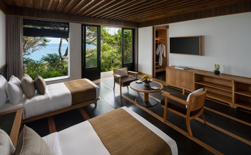 Four-bedroom ocean pool family residence bedroom at Amanoi, Vietnam, with bed, wooden furniture and ocean view.