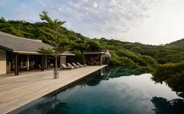 Amanoi resort-ի չորս հարկանի օվկիանոսային լողավազանի ընտանեկան բնակավայրի սվիммինգ լողավազանի տերասա, անշարժ ջրի դիմաց փայտե տերասա։