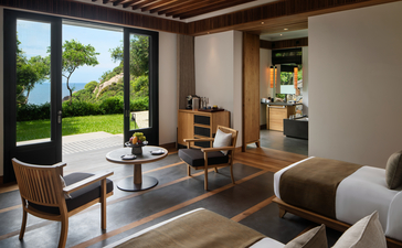 安缦诺怡度假村海景泳池家庭别墅的卧室，配有现代家具和落地窗。