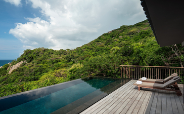 安缦诺怡度假村的家庭泳池别墅，木制甲板俯瞰翠绿山峦与碧蓝海水。