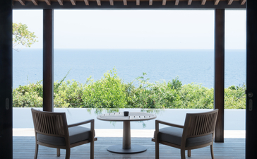 Terrace at Amanoi with two chairs facing a plunge pool and coastal views beyond.