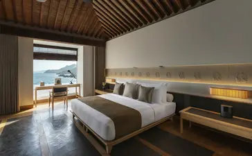 Principal bedroom at Amanoi with twin beds, wooden ceiling and sea view from terrace.