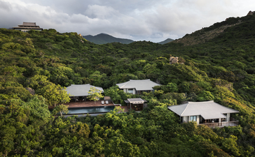 アマノイ・リゾートを上空から見た様子。緑に覆われた山々に建つ白い建物群が点在しています。