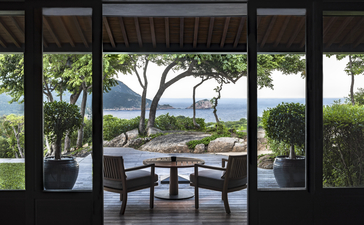 アマノイ リゾートの4ベッドルーム レジデンスのテラスから、庭園と海の景色を望む。