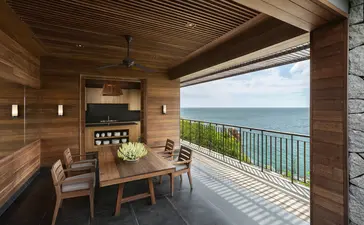 Amanoi terrace with dining area overlooking coastal landscape and sea horizon.