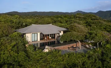 Aerial view of an ocean pool villa at Amanoi surrounded by verdant tropical forest and mountains.