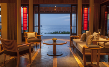 Ocean Pool Villa living room at Amanoi with seating areas overlooking the sea at dusk.