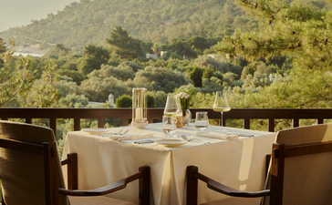 Private dining table set for wine tasting at Amanruya, Turkey, with mountain views.