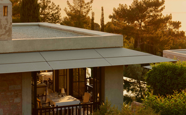 Amanruya dining venue at sunset overlooking the Turkish coastline and sea.