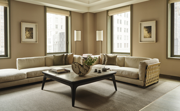 Salotto di una suite angolare presso l'hotel Aman New York, con divani beige e tavolino basso in legno scuro.