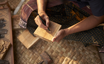 Instructor demonstrating wood carving techniques at Amandari, Indonesia.