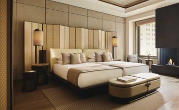 Chambre avec lits jumeaux à Aman New York, mobilier bois clair et accents dorés.