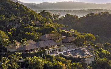 Vista aérea de Amankila resort entre colinas boscosas y valle.