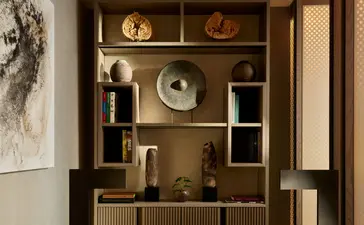 Aman Suite con estantería de madera con objetos decorativos en Aman New York, hotel.