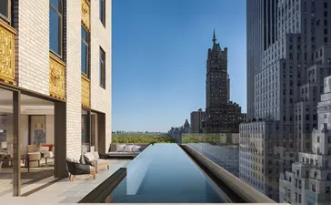 Piscina alargada junto a edificios de piedra con vistas a la ciudad en Aman New York.