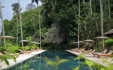 Piscina del club de playa rodeada de vegetación tropical en Amankila resort, Bali.