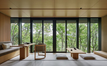 Washigamine Suite at Aman Kyoto with expansive windows framing forest views, minimalist interior and natural materials.
