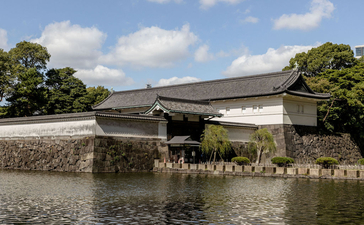 Aman Tokyo's modern bridge spanning the moat beside the Imperial Palace's stone walls.