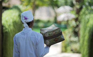 Staff member holding incense stick at Aman Villas Nusa Dua, Indonesia.