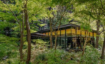 Modern black and yellow pavilion nestled amongst spring greenery at Aman Tokyo.
