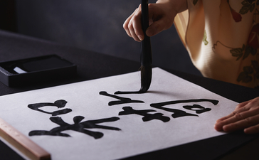 Hands practising traditional calligraphy at Aman Tokyo.