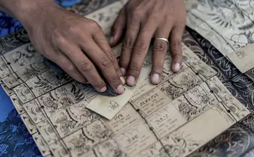Hands examining architectural blueprints at Amankila.