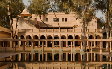 Amanbagh's main building with colonnade courtyard and reflecting pool at dusk.