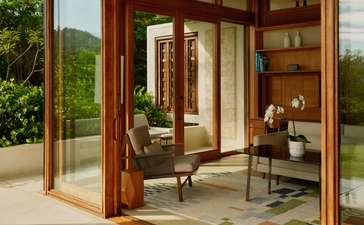 Amanera's open pavilion with wooden frames overlooking tropical gardens and seated seating areas.