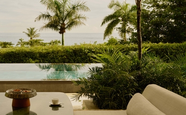 Amanera's contemplative landscape, with stone viewing platform overlooking tranquil waters and lush gardens.