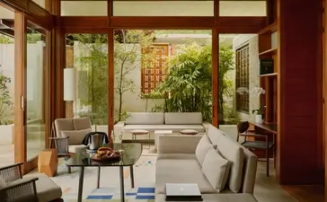 Amanera casita interior with wooden-framed glass doors opening onto a garden courtyard.