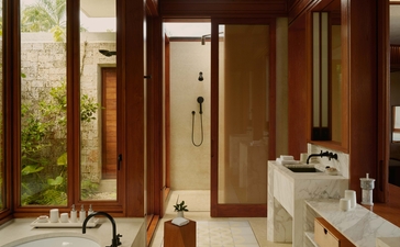Casita bathroom at Amanera resort with wooden screens, natural light, and stone basin.
