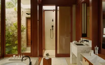 Casita bathroom at Amanera with wooden finishes, stone sink, and access to outdoor garden space.