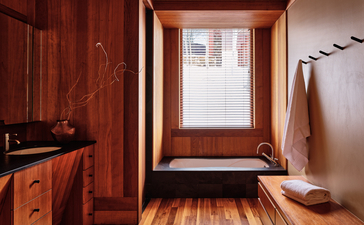 Wooden-clad bathroom at Amangani with skylight window and copper sink.