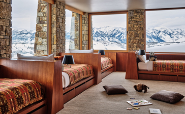 Amangani lounge with terracotta seating, floor cushions, and snow-capped mountain views through expansive windows.