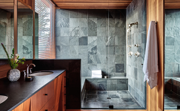 West Tatanka House bathroom at Amangani with wooden vanity, slate shower enclosure and natural stone finishes.