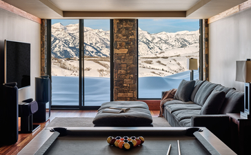 West Tatanka House principal bedroom at Amangani with panoramic mountain and water views through floor-to-ceiling windows.