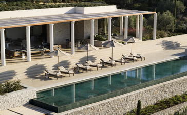 Villa 22 at Amanzoe resort, with sunbeds beneath a covered terrace overlooking an infinity pool.