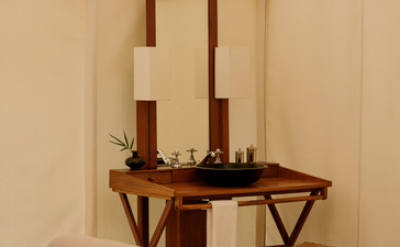 Bathroom vanity with mirror and wooden furnishings inside a tent at Aman-i-Khas.