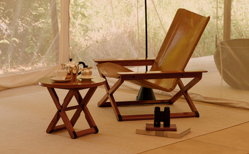 Wooden chair and table furniture displayed at the tent entrance of Aman-i-Khas, India.