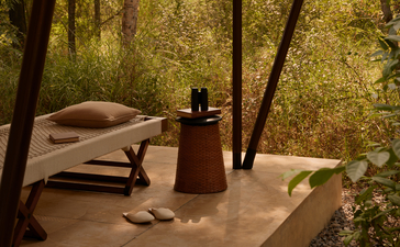 Outdoor tent interior at Aman-i-Khas with cushions, lantern and natural light filtering through canvas walls.