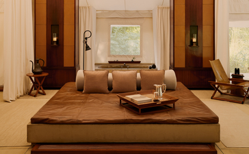 Spacious tent living area at Aman-i-Khas with low platform seating and warm earth tones throughout.