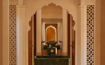 Pool pavilion with symmetrical archways and decorative tilework at Amanbagh, India.