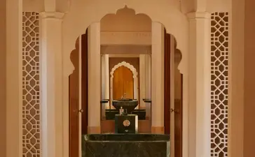 Pool pavilion with symmetrical archways and decorative tilework at Amanbagh, India.