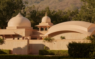Pool pavilion at Amanbagh overlooking the water and domed architecture beyond.