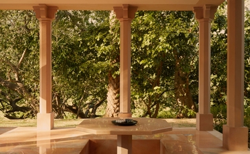 Pool pavilion at Amanbagh with timber columns framing verdant garden views.