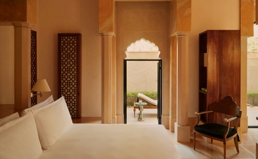 Garden Haveli Suite at Amanbagh with principal bed, arched doorway and traditional Indian architectural details.