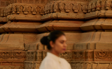 Woman practising yoga at Bhangarh Fort temple ruins, Amanbagh.