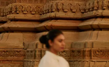 Woman practising yoga at Bhangarh Fort temple ruins, Amanbagh.